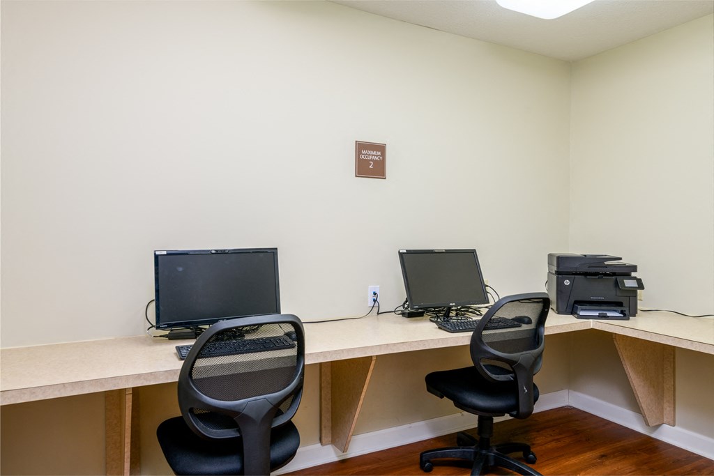 an office with two desks with computers and chairs