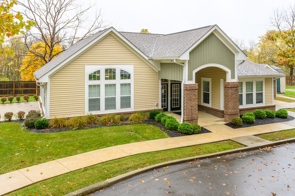 the front of a house with a driveway and lawn