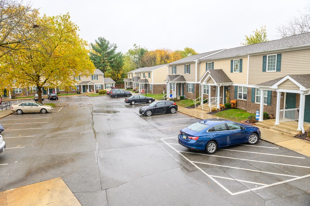 a parking lot filled with cars in front of houses