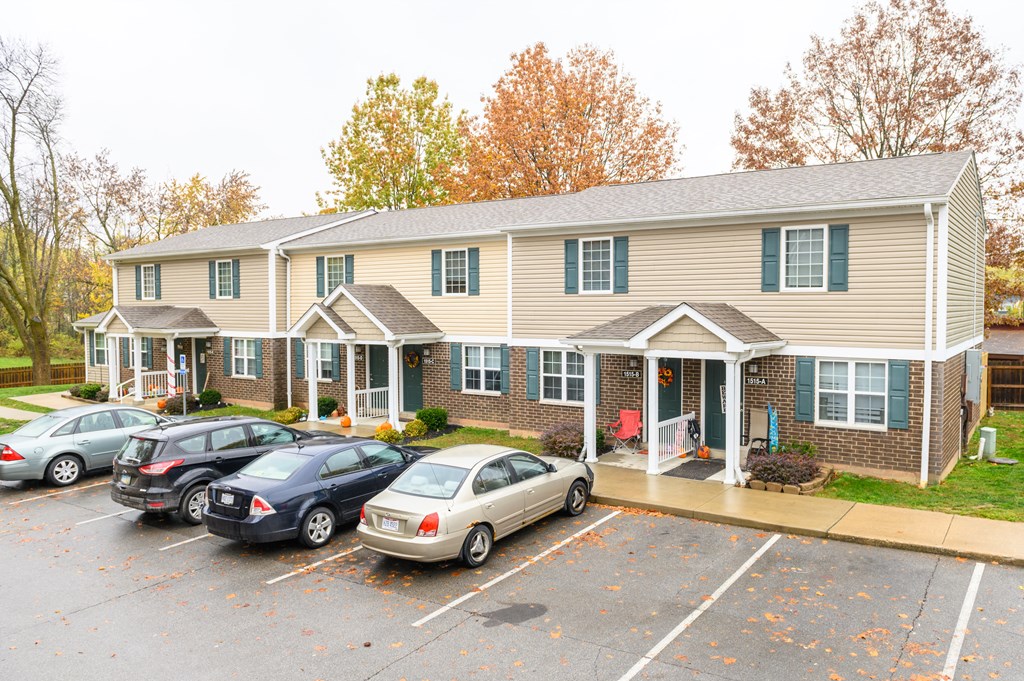 a parking lot with cars in front of a house
