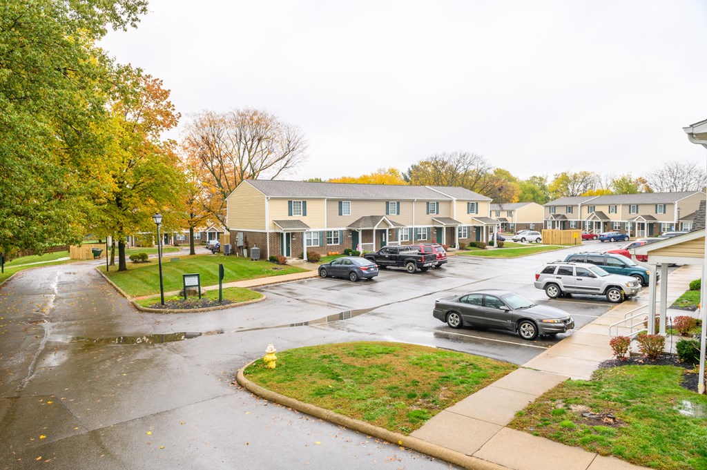 the view of a street with cars parked in front of houses