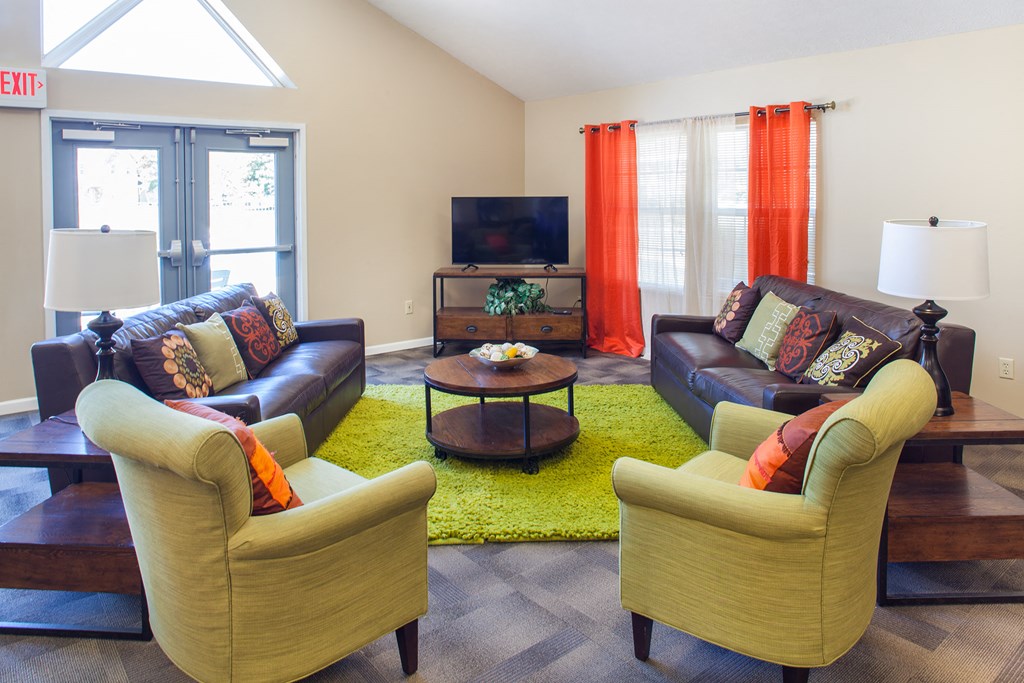 a living room with couches and chairs and a television