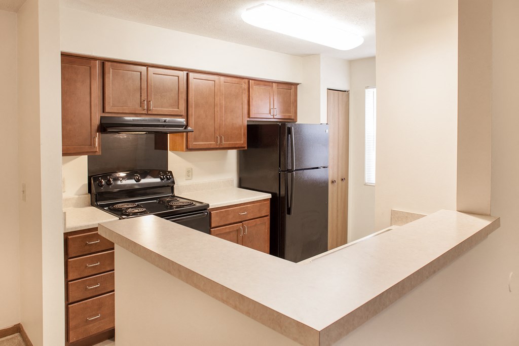 a kitchen with a counter top and a black refrigerator