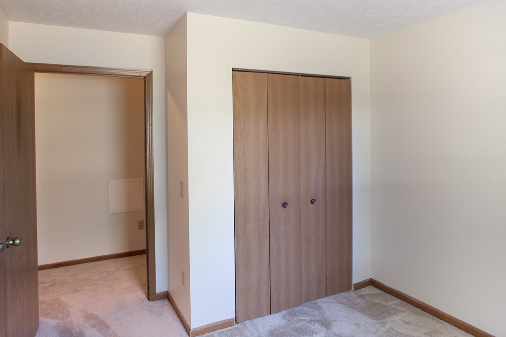 a bedroom with a closet and a door to a bathroom