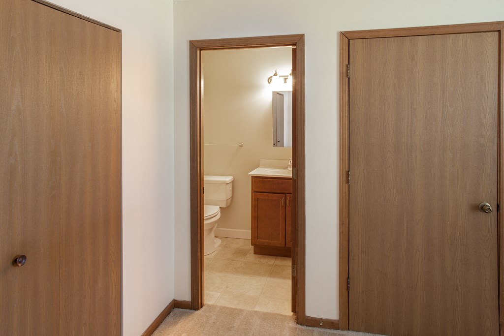 a bathroom with two doors and a toilet and a sink