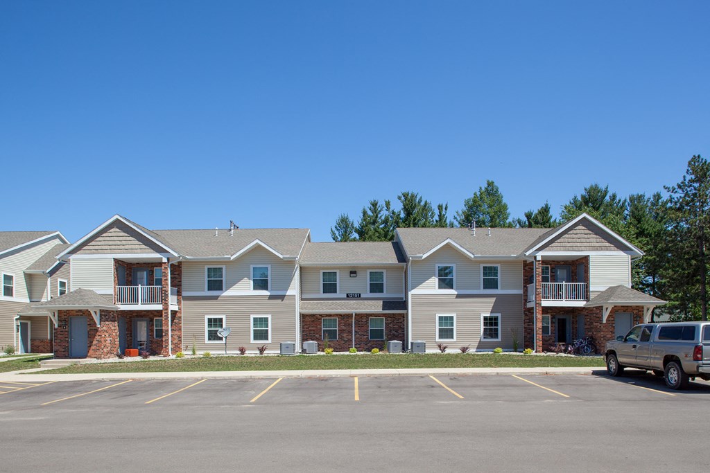 an apartment building with a parking lot and a truck in front of it