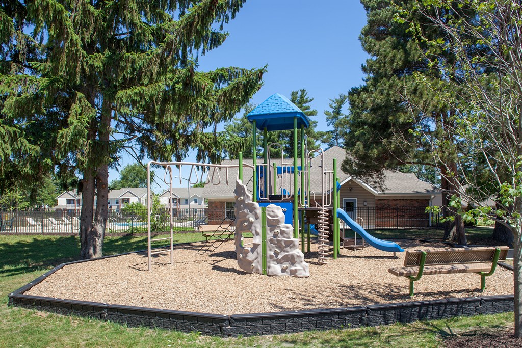 a playground with a slide and a bench in a park