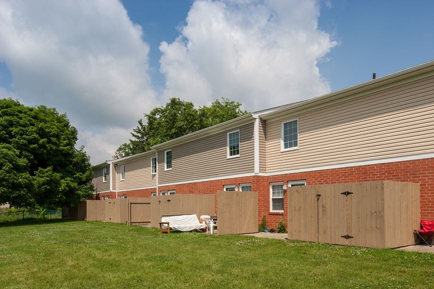 a backyard with a fence and a brick house