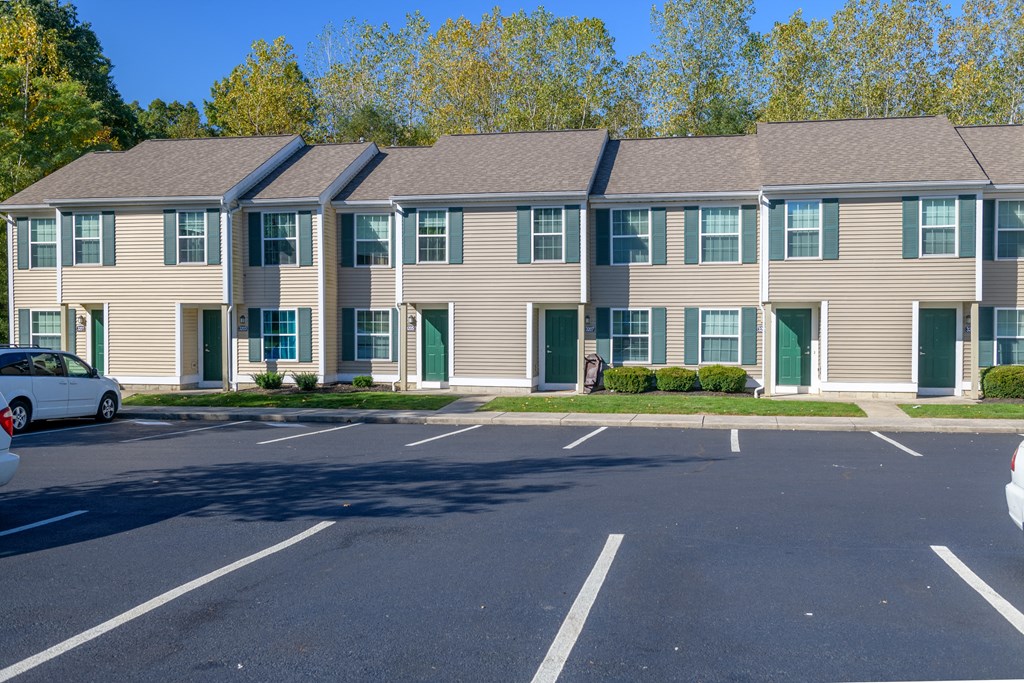 an apartment building with a parking lot in front of it