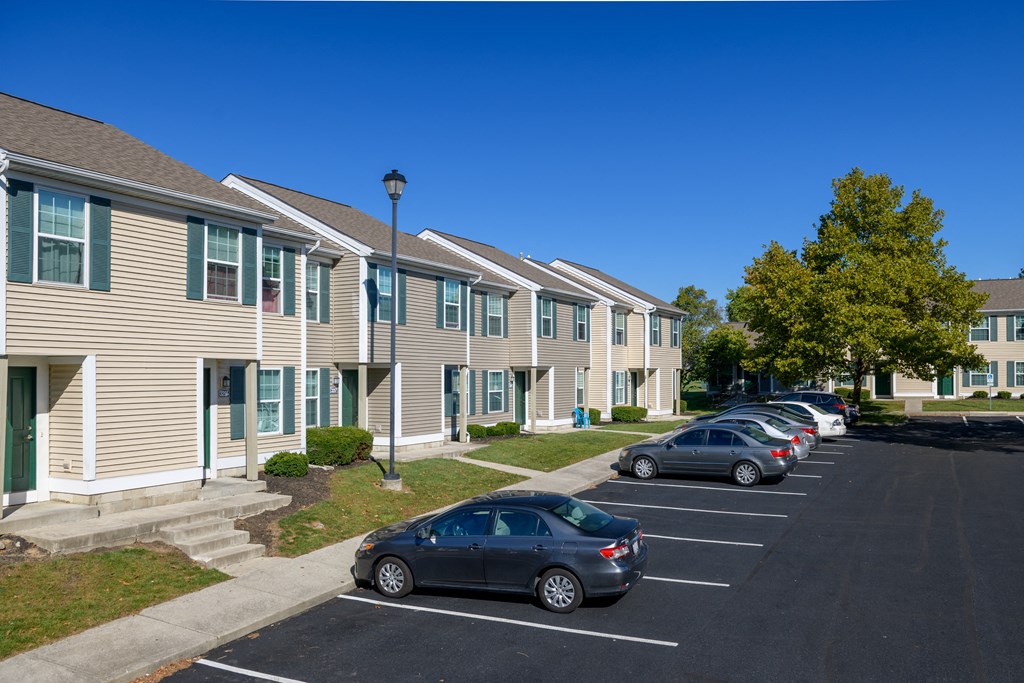 a row of houses with cars parked in a parking lot