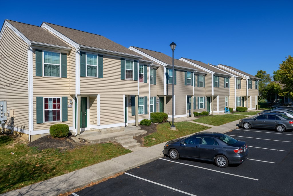 a row of town homes with cars parked in front