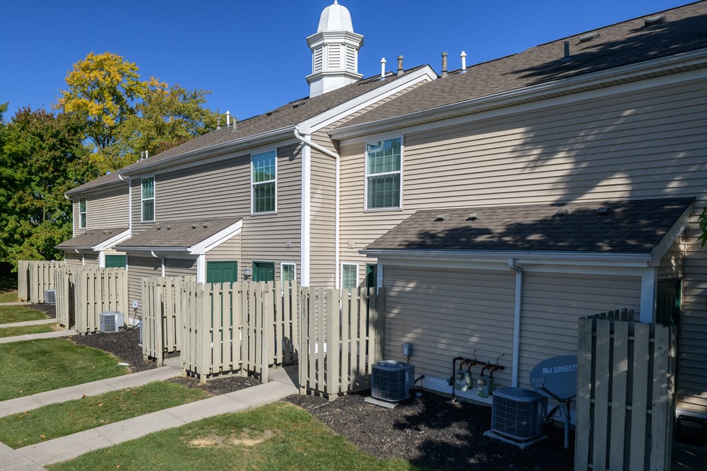 the side of a house with a white picket fence
