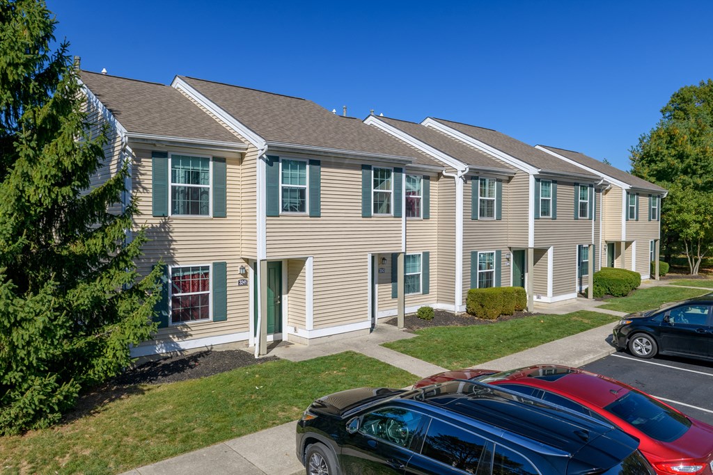 an apartment building with cars parked in front of it