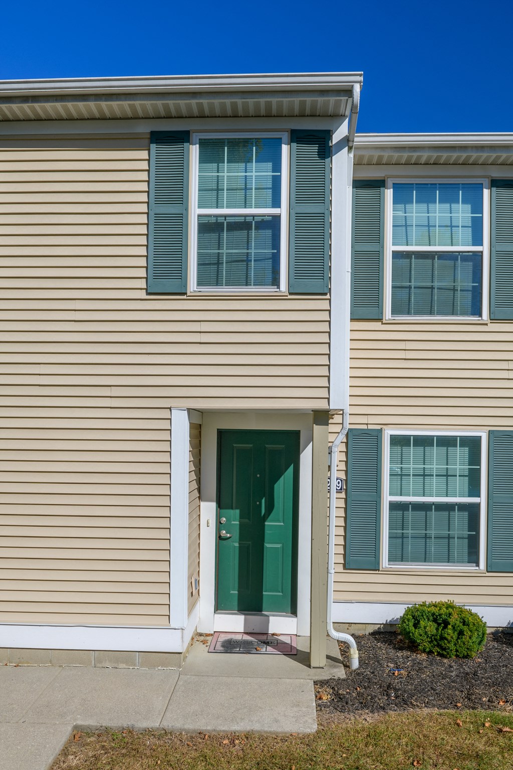 the front of a house with a green door