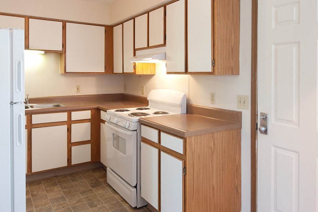 a kitchen with white appliances and wooden cabinets