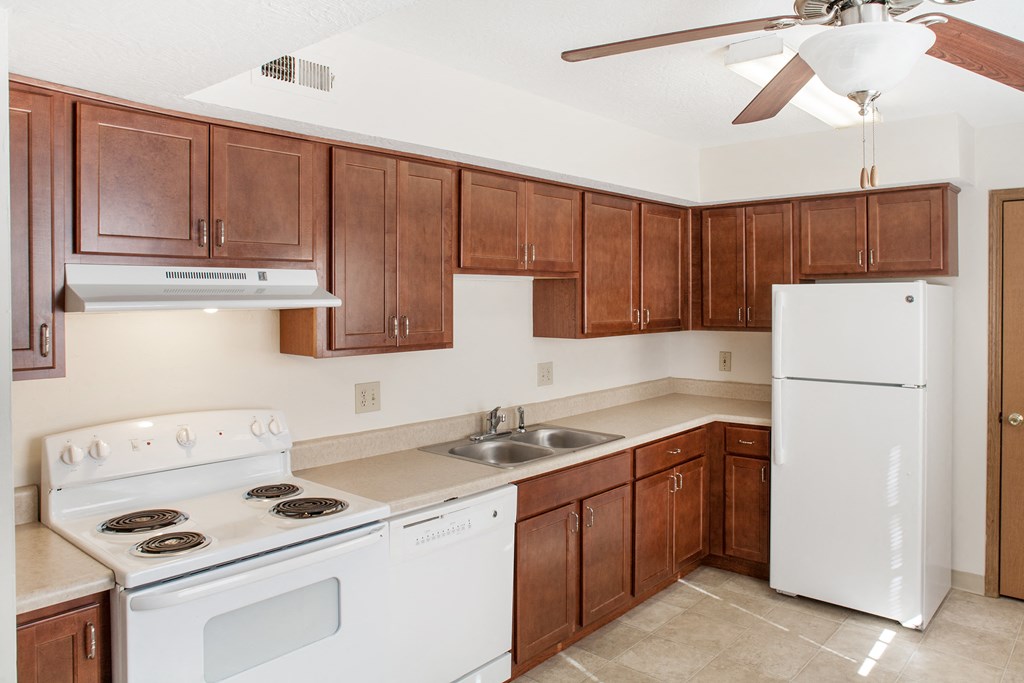 a kitchen with white appliances and wooden cabinets