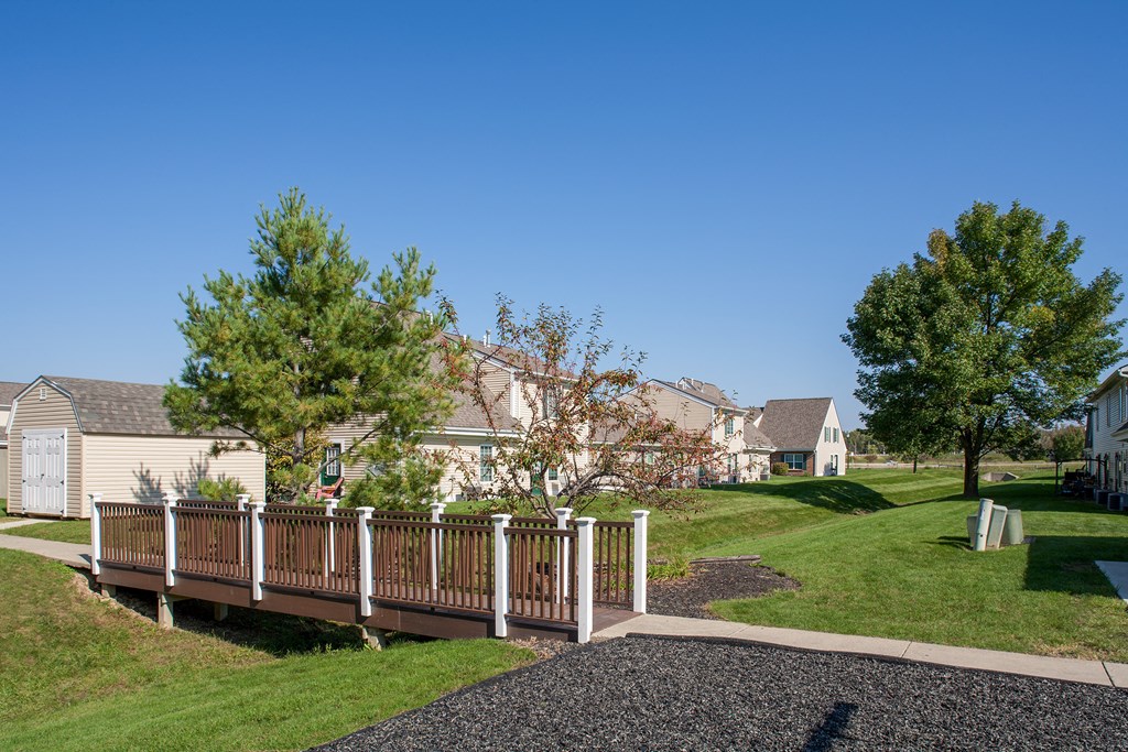 a deck with a fence in front of a row of houses