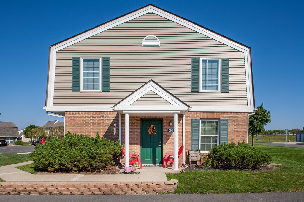 the front of a house with a green door