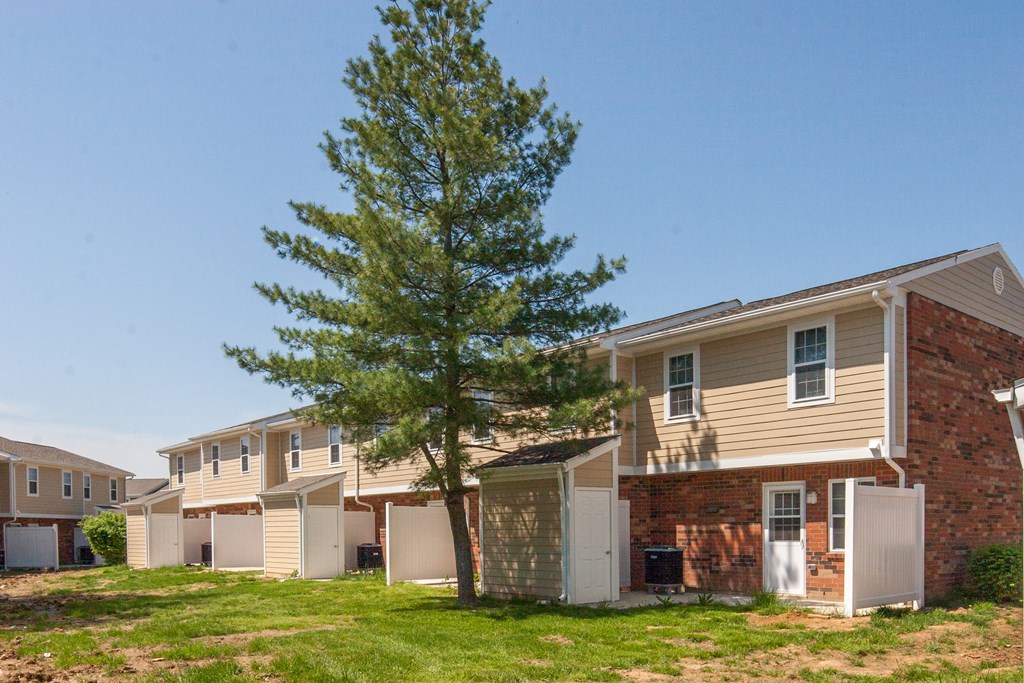an apartment building with a tree in front of it