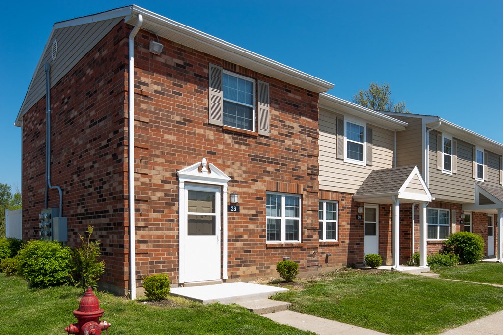 an apartment building with a red fire hydrant in front of it