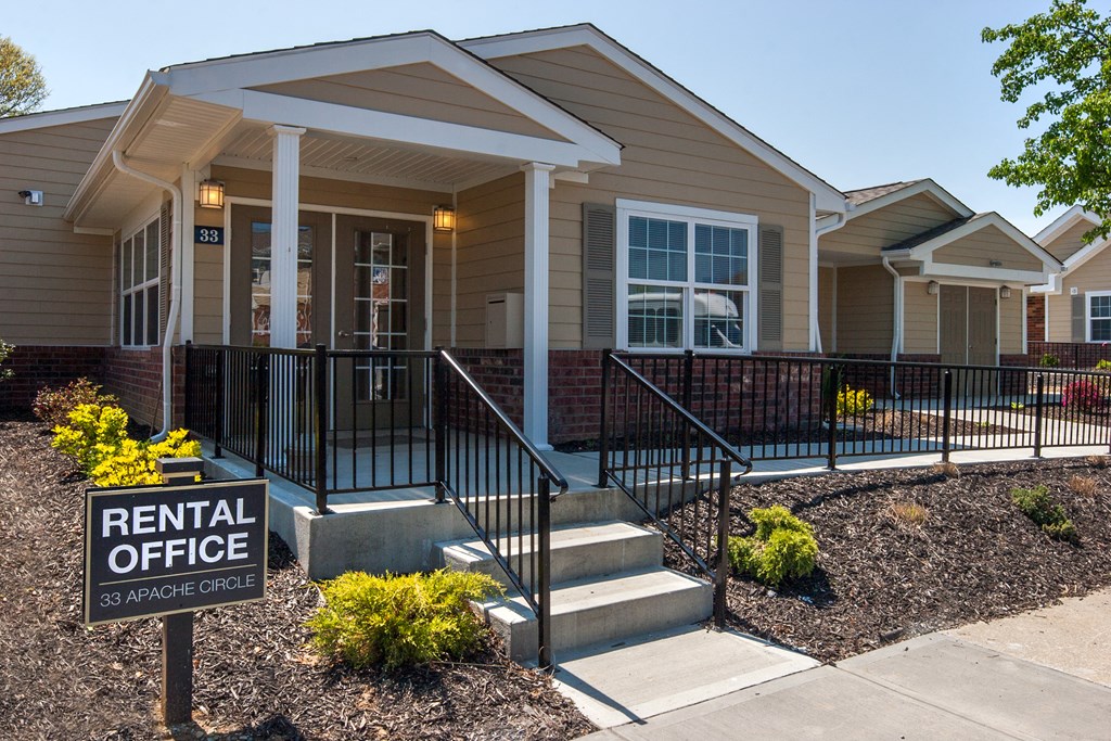 a rental office sign in front of a house