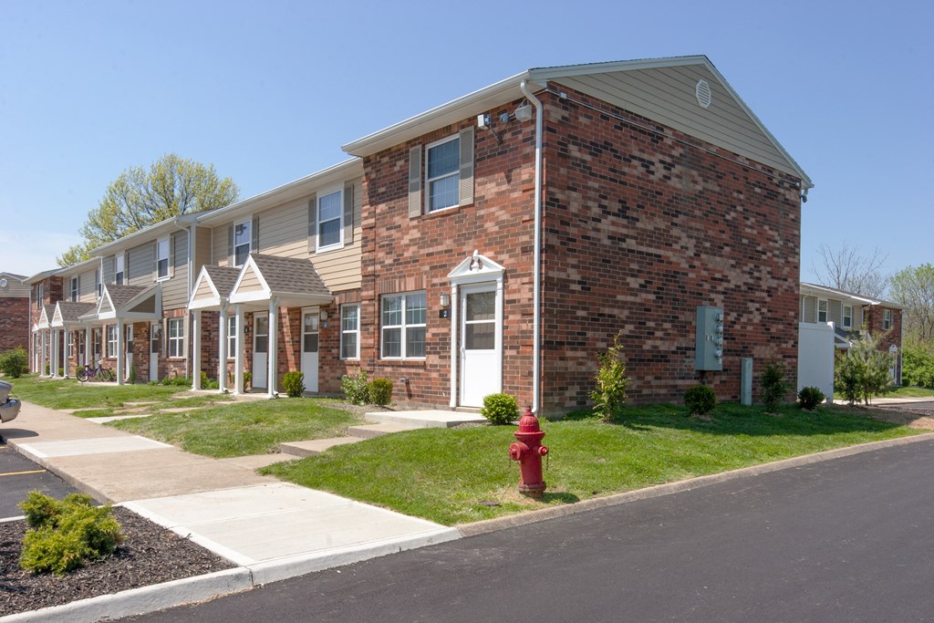 an apartment building with a red fire hydrant in front of it