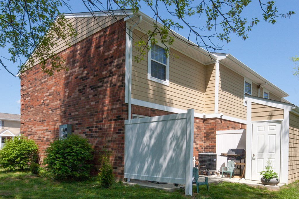 an old brick house with a fence in front of it