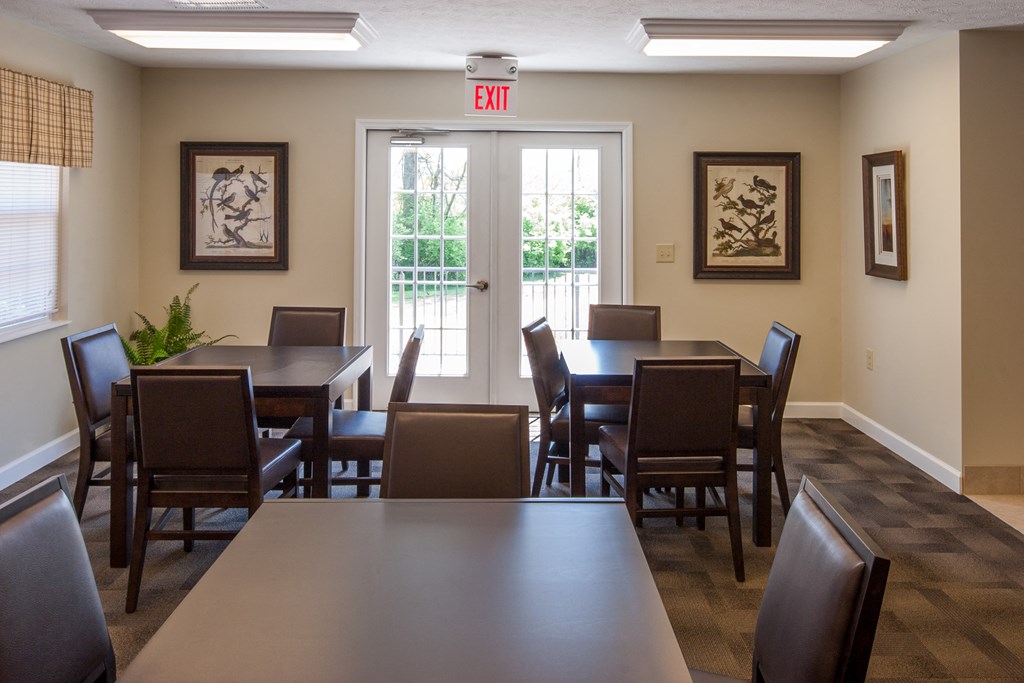 a dining room with tables and chairs and a exit sign on the wall