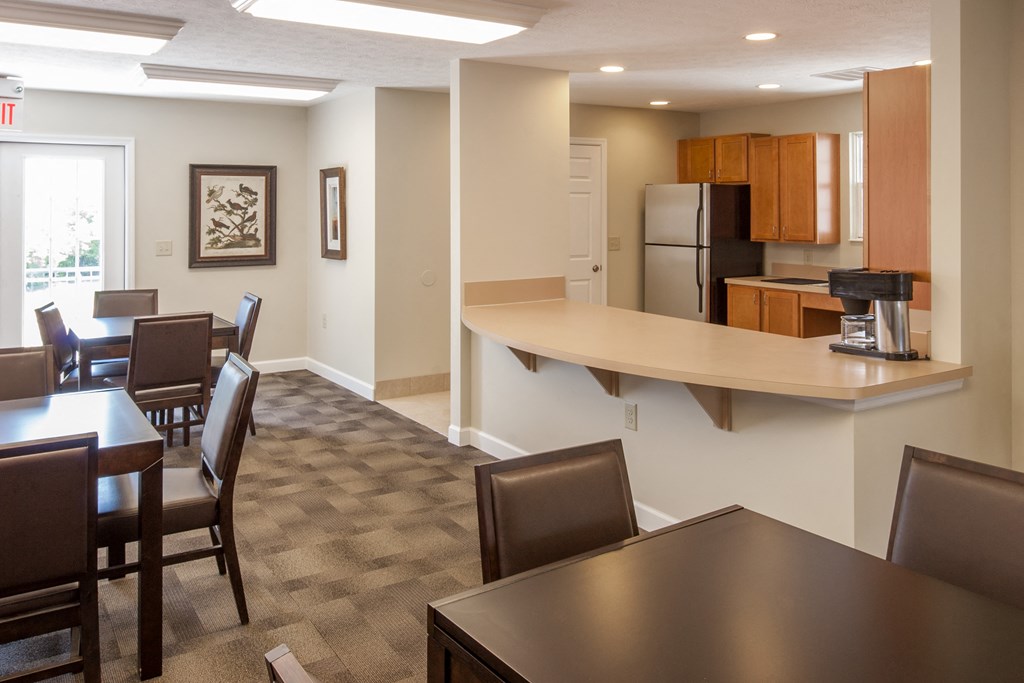 a dining room and kitchen with a bar and a table and chairs
