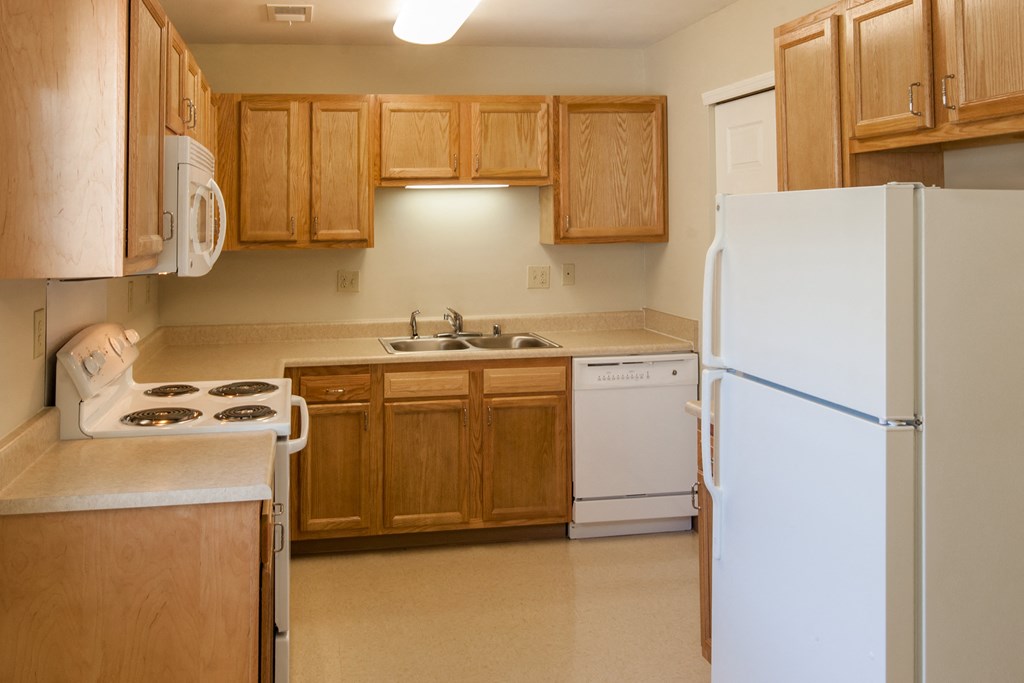a kitchen with white appliances and wooden cabinets