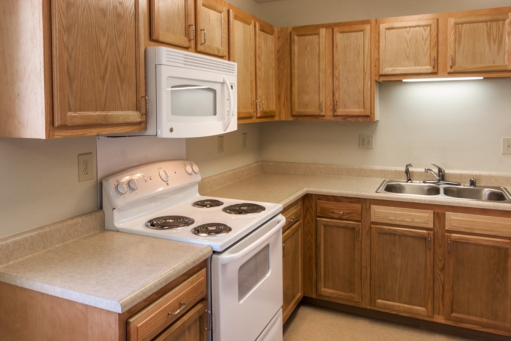 a kitchen with a stove and a sink and a microwave