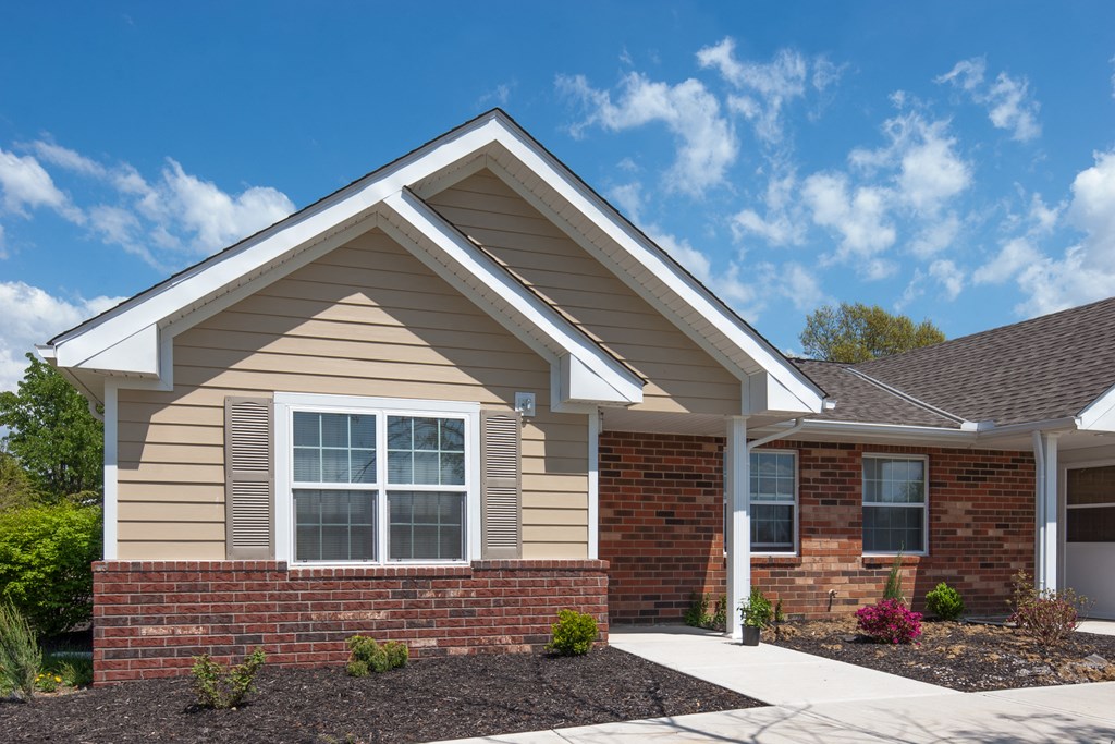a brick house with a sidewalk in front of it