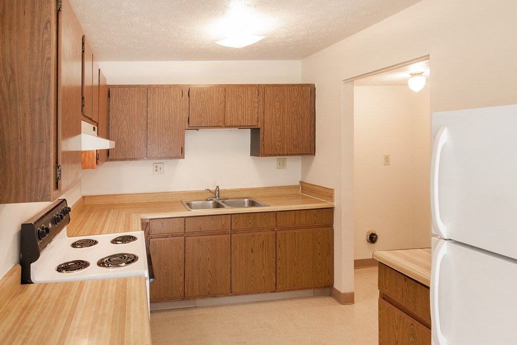 a kitchen with wooden cabinets and a stove and a sink