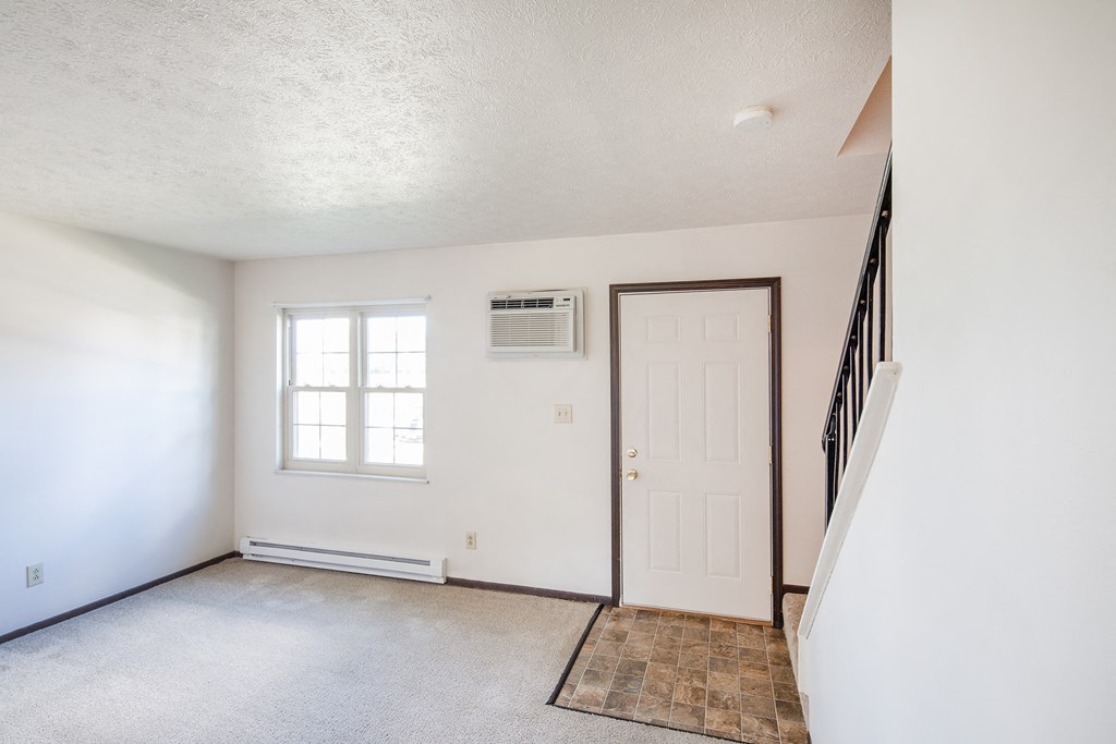 an empty living room with white walls and a white door