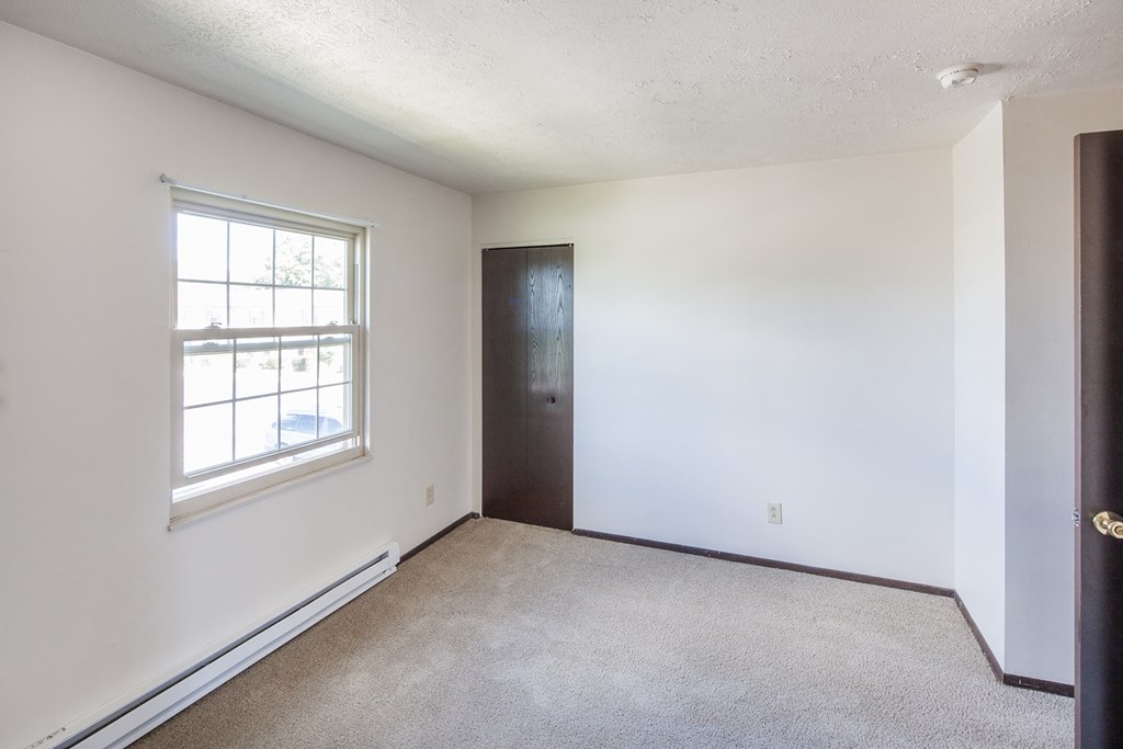 an empty room with white walls and a window and a door