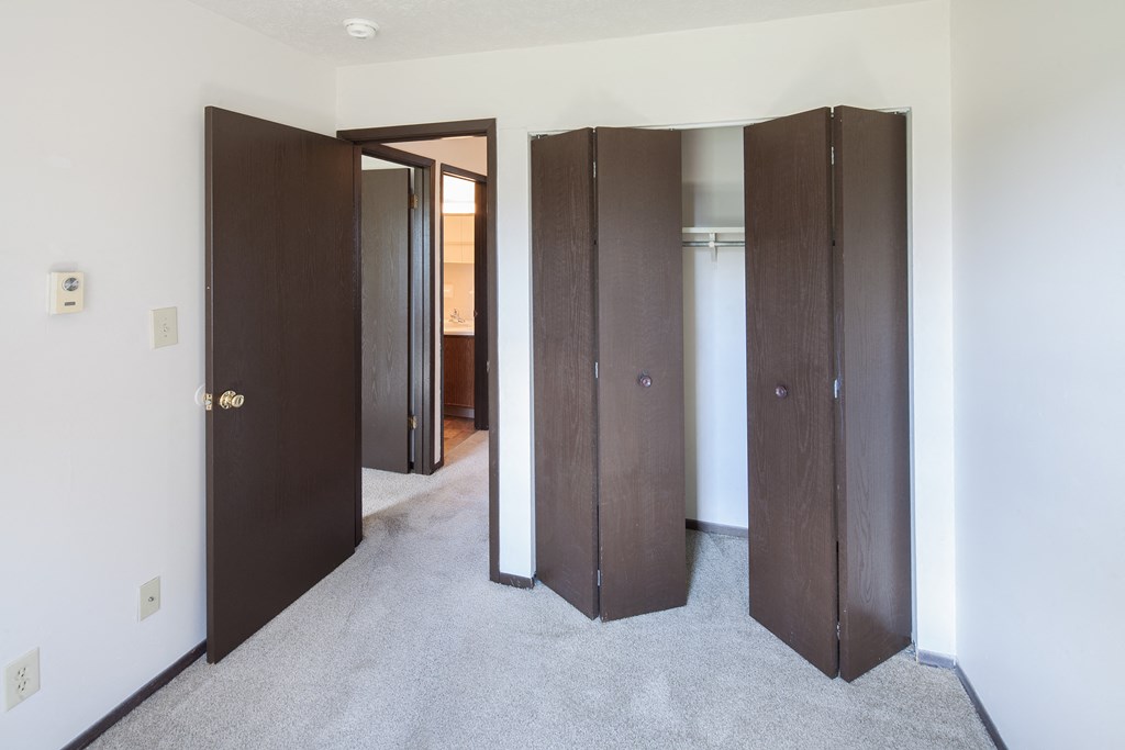 an empty room with three closet doors in it