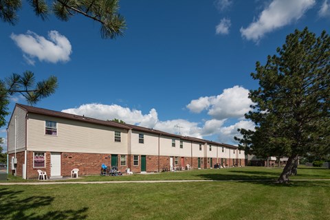 A long building with a green lawn in front.