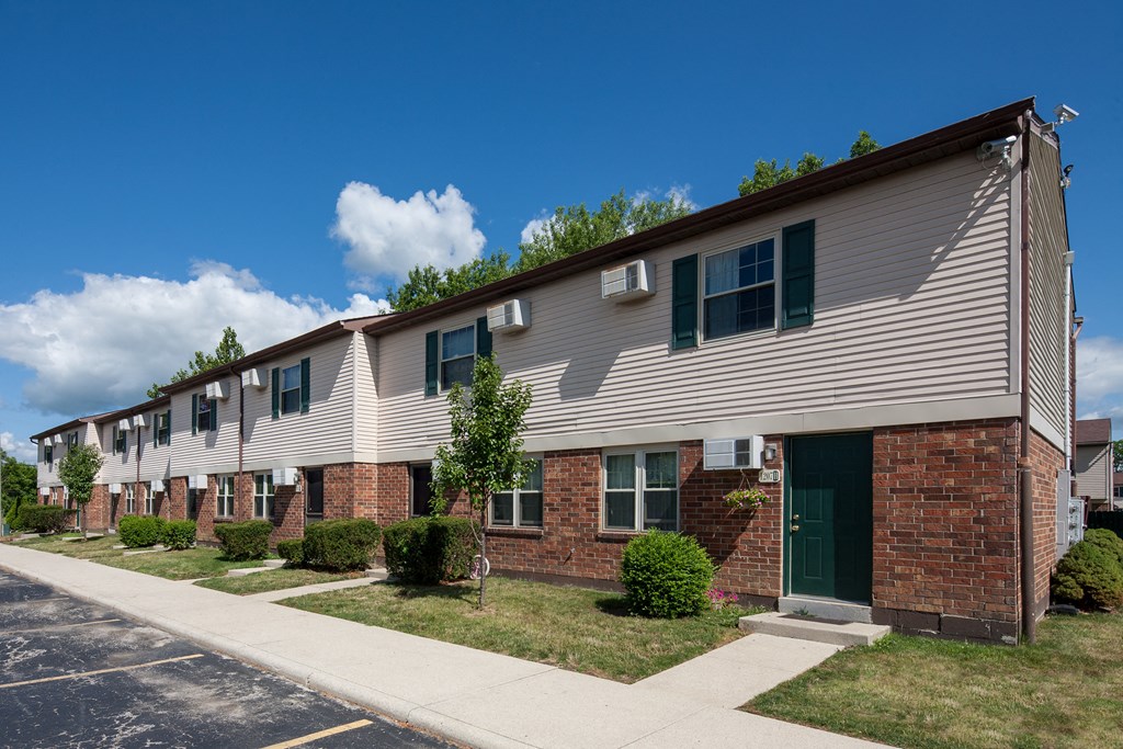 A row of houses with green doors and windows.