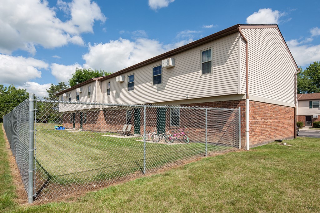 the side of a house behind a chain link fence