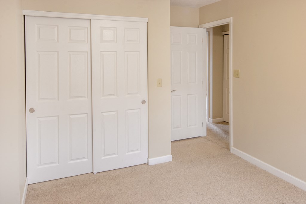 a bedroom with two closets and a door to a hallway
