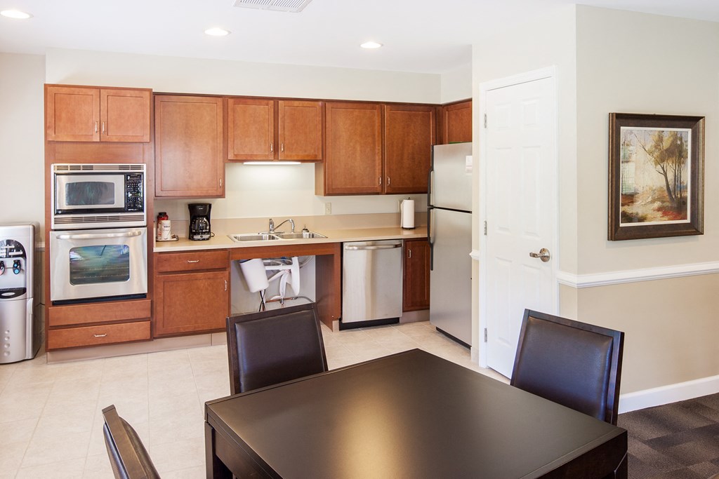 a kitchen with wooden cabinets and appliances and a table and chairs