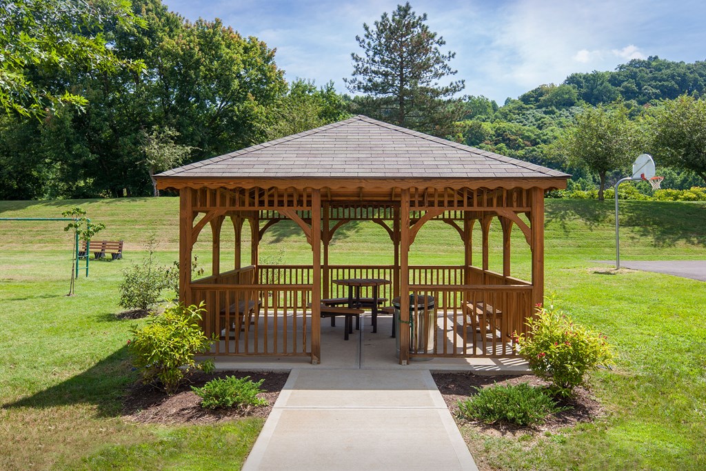 a gazebo with a table and chairs in a park
