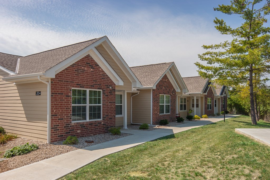 a row of houses with a sidewalk in front of them