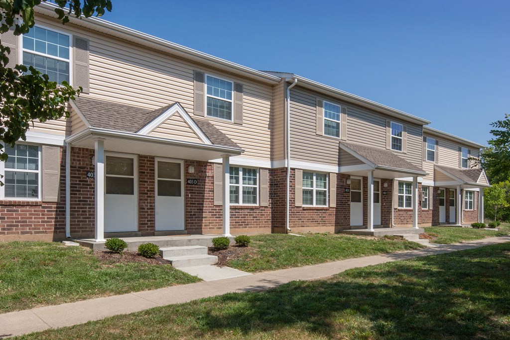 an apartment building with a sidewalk in front of it