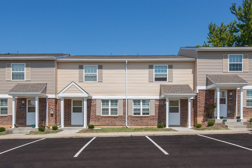 an apartment building with a parking lot in front of it