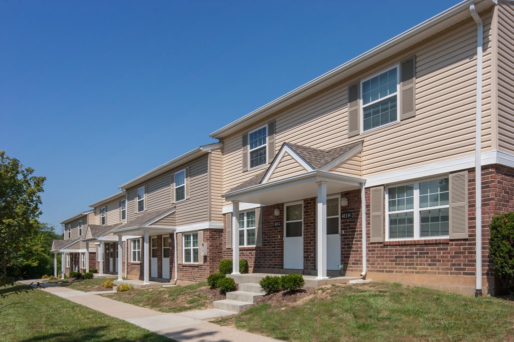 a row of houses with a sidewalk in front of them