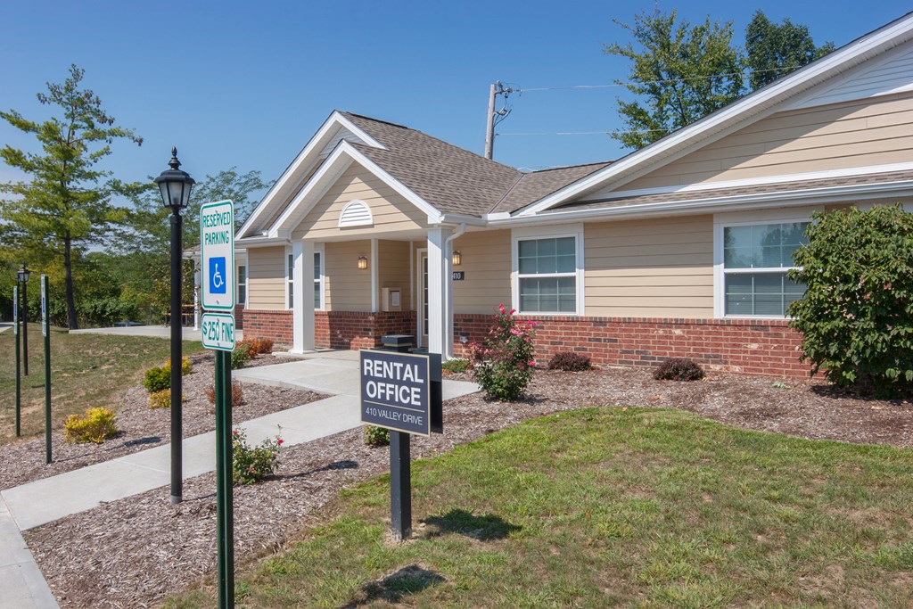 a house with rental office signs in front of it