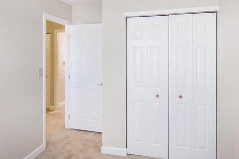 a bedroom with two closets and a door to a hallway
