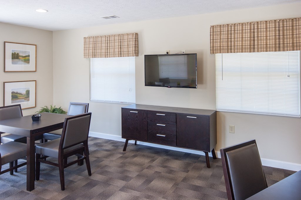 a dining room with a table and chairs and a television