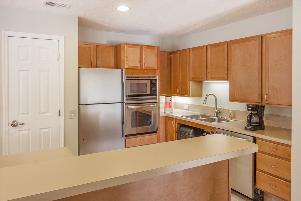 a kitchen with stainless steel appliances and wooden cabinets